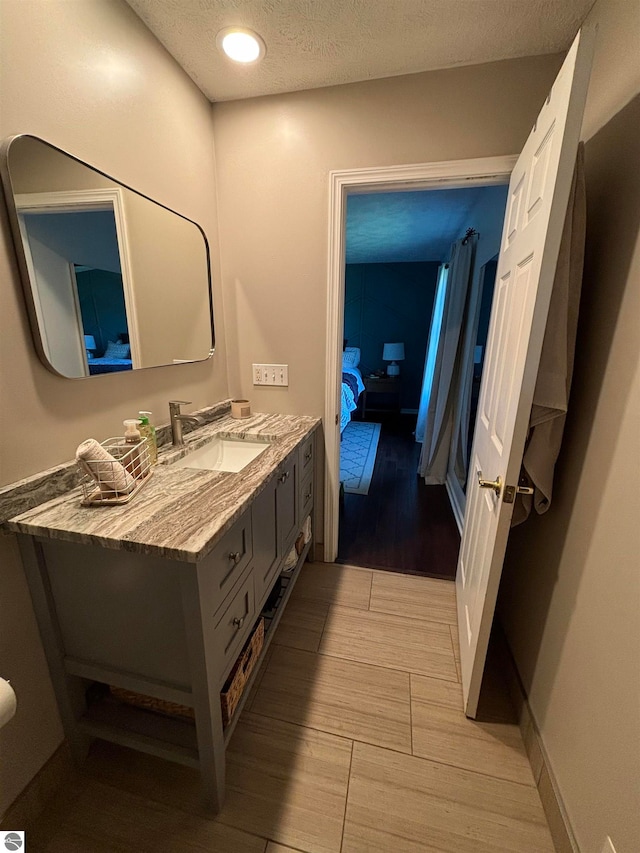 bathroom featuring hardwood / wood-style floors, a textured ceiling, and vanity