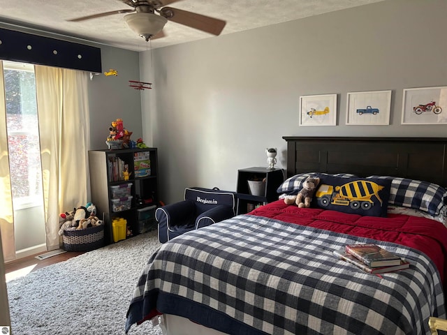 bedroom with ceiling fan and a textured ceiling