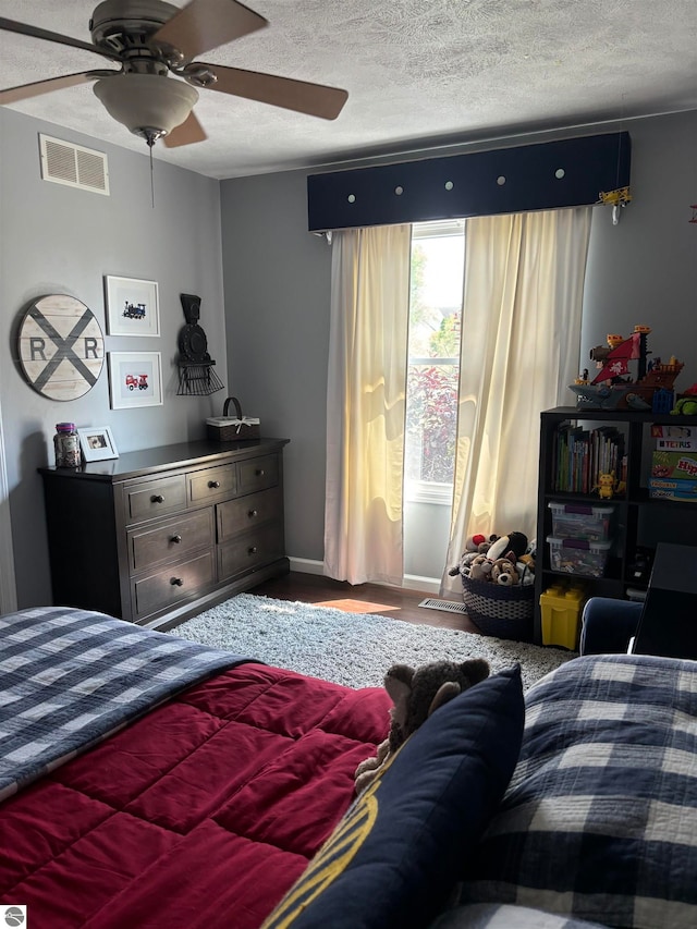 bedroom with ceiling fan and a textured ceiling