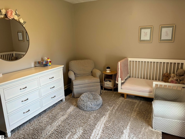 sitting room featuring dark colored carpet