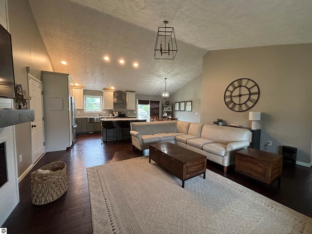 living room featuring a textured ceiling, lofted ceiling, and dark hardwood / wood-style floors