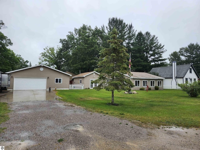 single story home featuring a front yard, a garage, and driveway