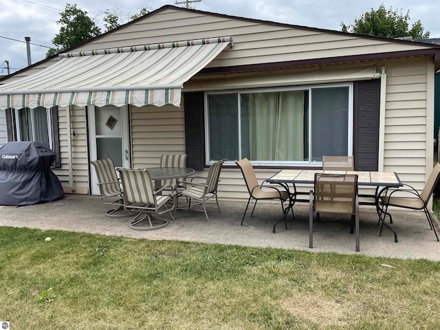 back of property with a lawn and a patio area