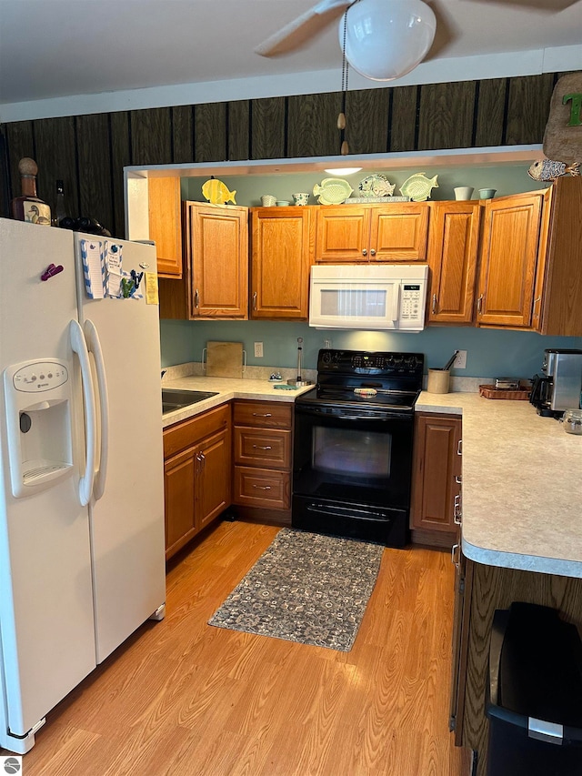 kitchen featuring sink, white appliances, ceiling fan, and light wood-type flooring