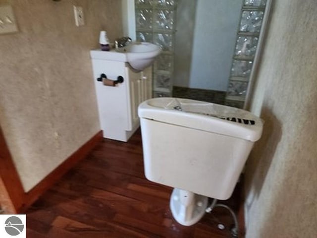 bathroom with hardwood / wood-style flooring and toilet