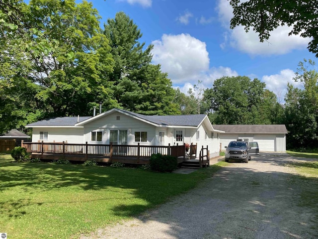 view of front of house featuring a garage, a front lawn, a deck, and an outbuilding