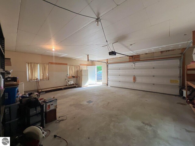 garage with freestanding refrigerator and a garage door opener