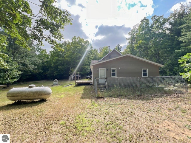 view of property exterior with fence and a lawn