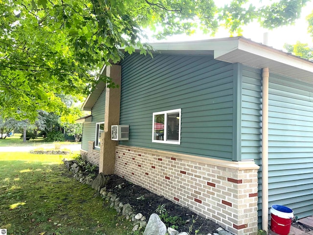 view of property exterior featuring an AC wall unit and a yard