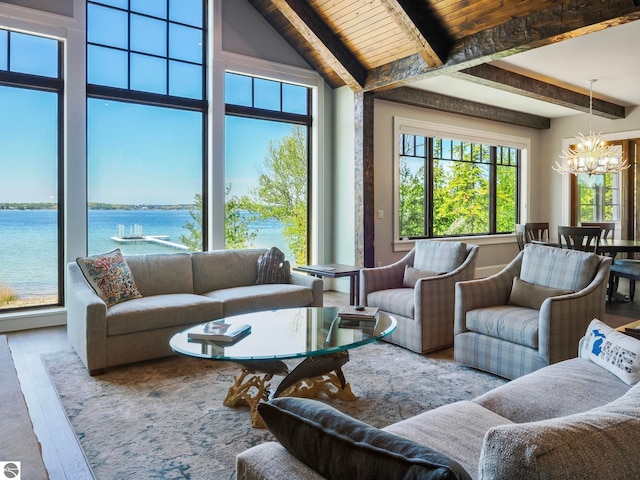 living room featuring beamed ceiling, high vaulted ceiling, wood-type flooring, an inviting chandelier, and a water view