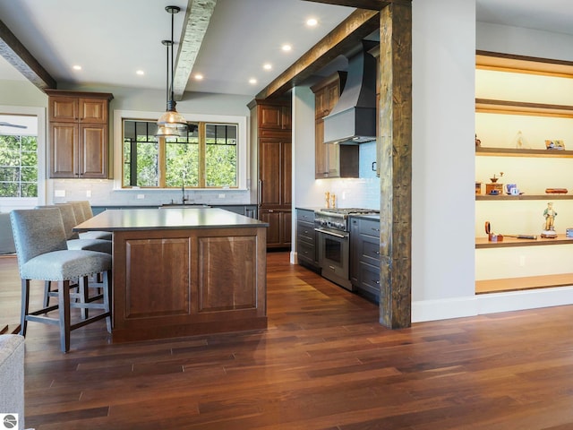 kitchen with premium range hood, tasteful backsplash, high end stainless steel range, a center island, and dark wood-type flooring