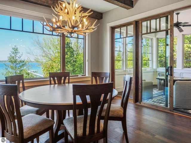 11305 Evergreen, Charlevoix, MI 49720 - dining area featuring a chandelier, wood finished floors, beamed ceiling, and a water view