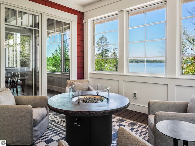 sunroom featuring plenty of natural light and a water view