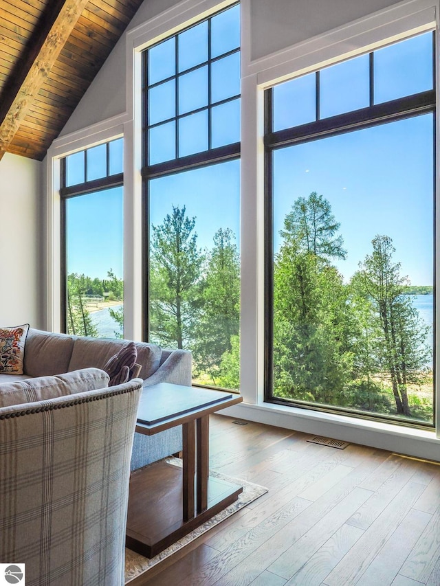 unfurnished living room featuring wooden ceiling, hardwood / wood-style flooring, beamed ceiling, and high vaulted ceiling