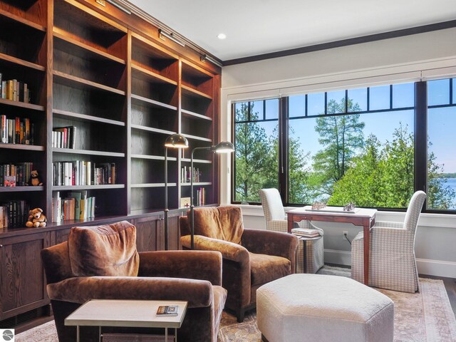 sitting room featuring a wealth of natural light, light wood-type flooring, and ornamental molding