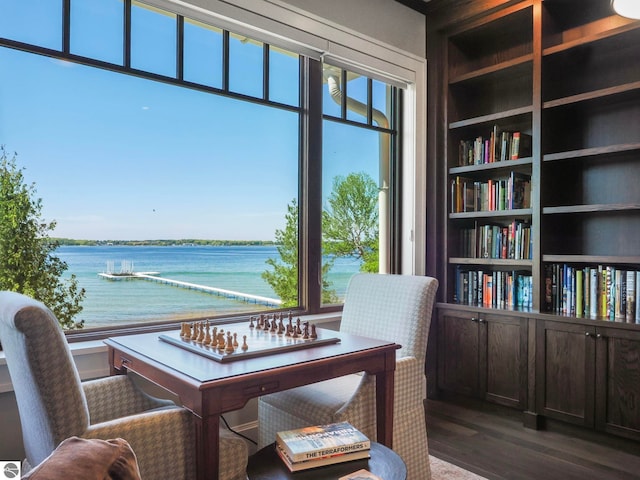 office featuring built in features, dark wood-type flooring, and a water view