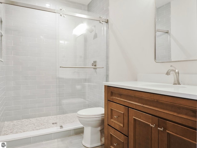 bathroom with tile patterned flooring, a shower with door, toilet, and vanity