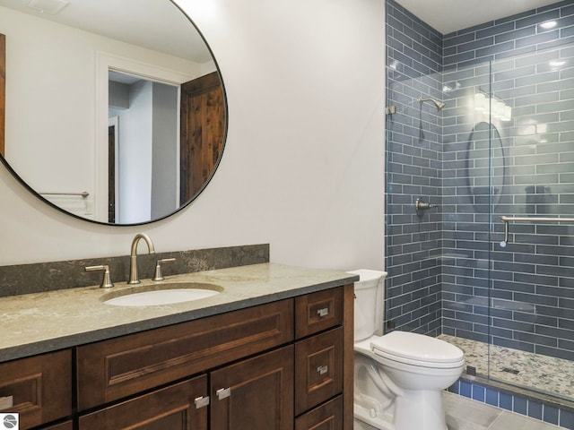 bathroom with tile patterned flooring, toilet, vanity, and walk in shower