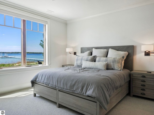 bedroom featuring light carpet, ornamental molding, and a water view