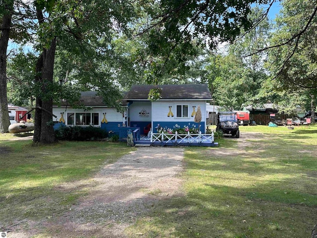 view of front of property with a deck and a front lawn