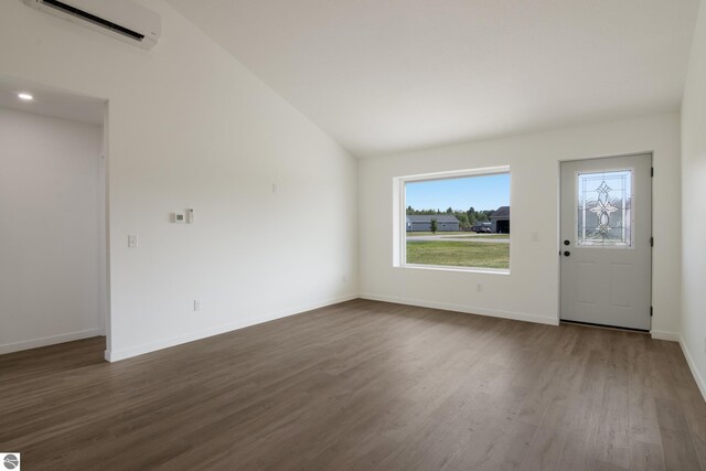 foyer featuring an AC wall unit, lofted ceiling, and wood-type flooring