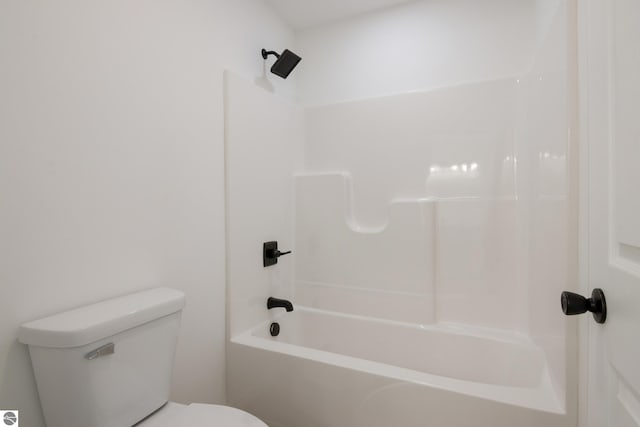 bathroom featuring tub / shower combination and toilet