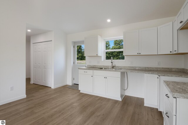 kitchen featuring sink, light hardwood / wood-style flooring, and white cabinets