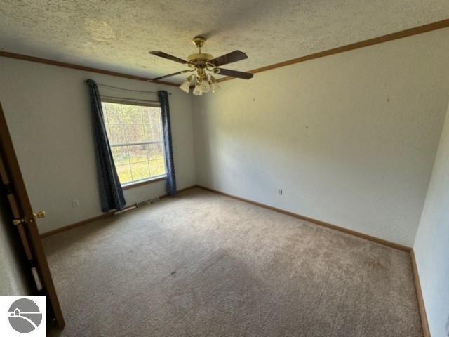 carpeted empty room with a textured ceiling and ceiling fan