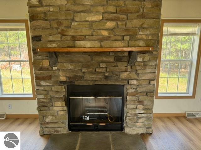 interior details with hardwood / wood-style flooring and a stone fireplace