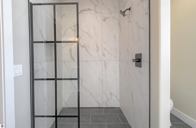 full bath with toilet and a marble finish shower