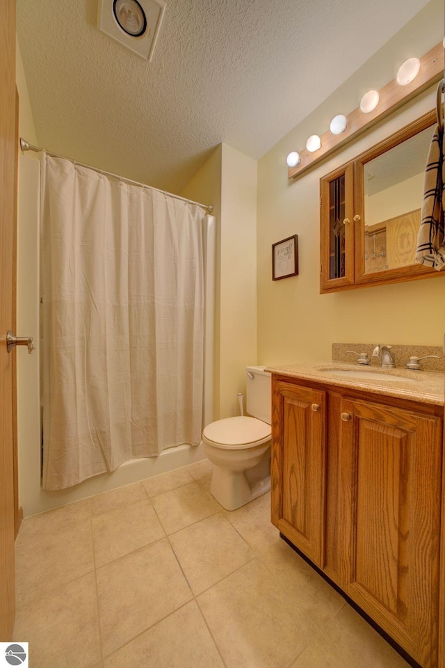 full bathroom with shower / bath combo, tile patterned floors, vanity, a textured ceiling, and toilet