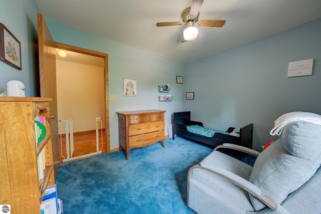 sitting room with carpet, ceiling fan, and a textured ceiling