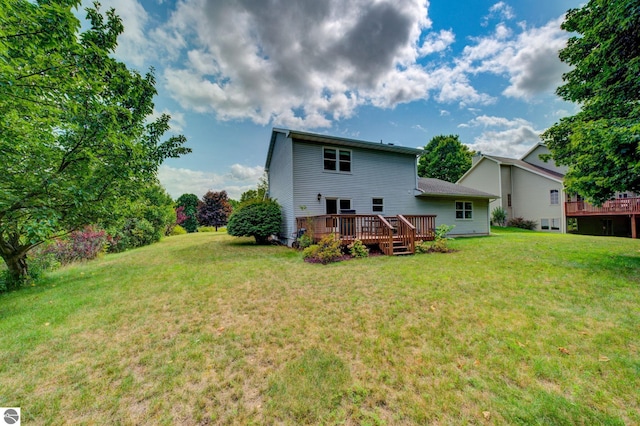 back of house with a deck and a lawn