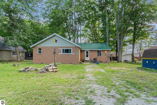 view of front of home with an outdoor fire pit, an outdoor structure, and a front yard