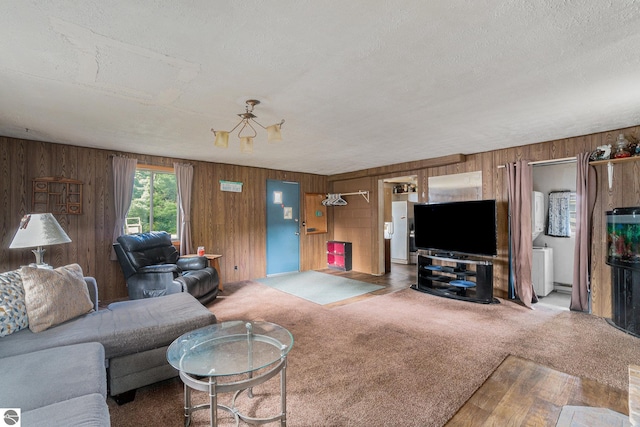 carpeted living room with a textured ceiling and wooden walls