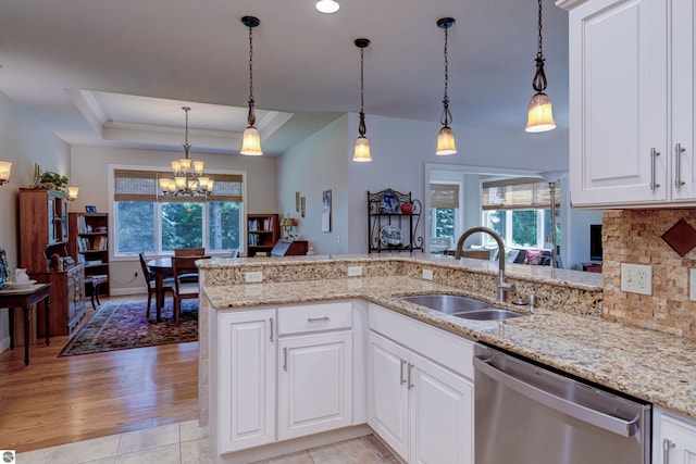 kitchen with kitchen peninsula, dishwasher, a tray ceiling, and sink