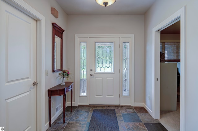 entrance foyer featuring dark tile patterned flooring