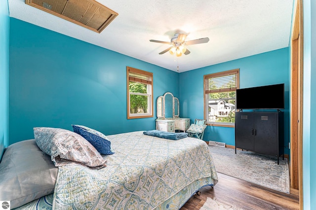 bedroom featuring ceiling fan, a textured ceiling, and hardwood / wood-style floors