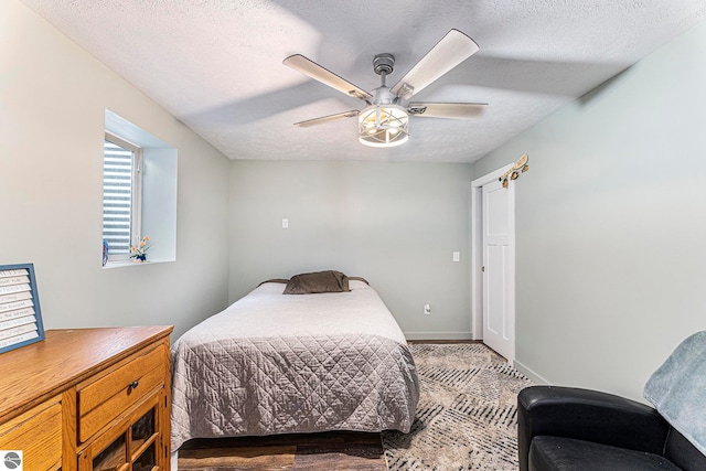 bedroom with ceiling fan and a textured ceiling