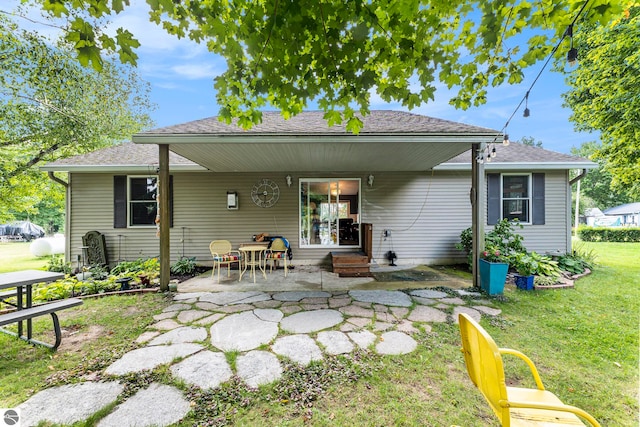 rear view of house with a lawn and a patio