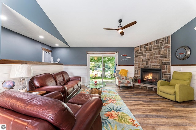 living room with hardwood / wood-style flooring, a fireplace, vaulted ceiling, and ceiling fan