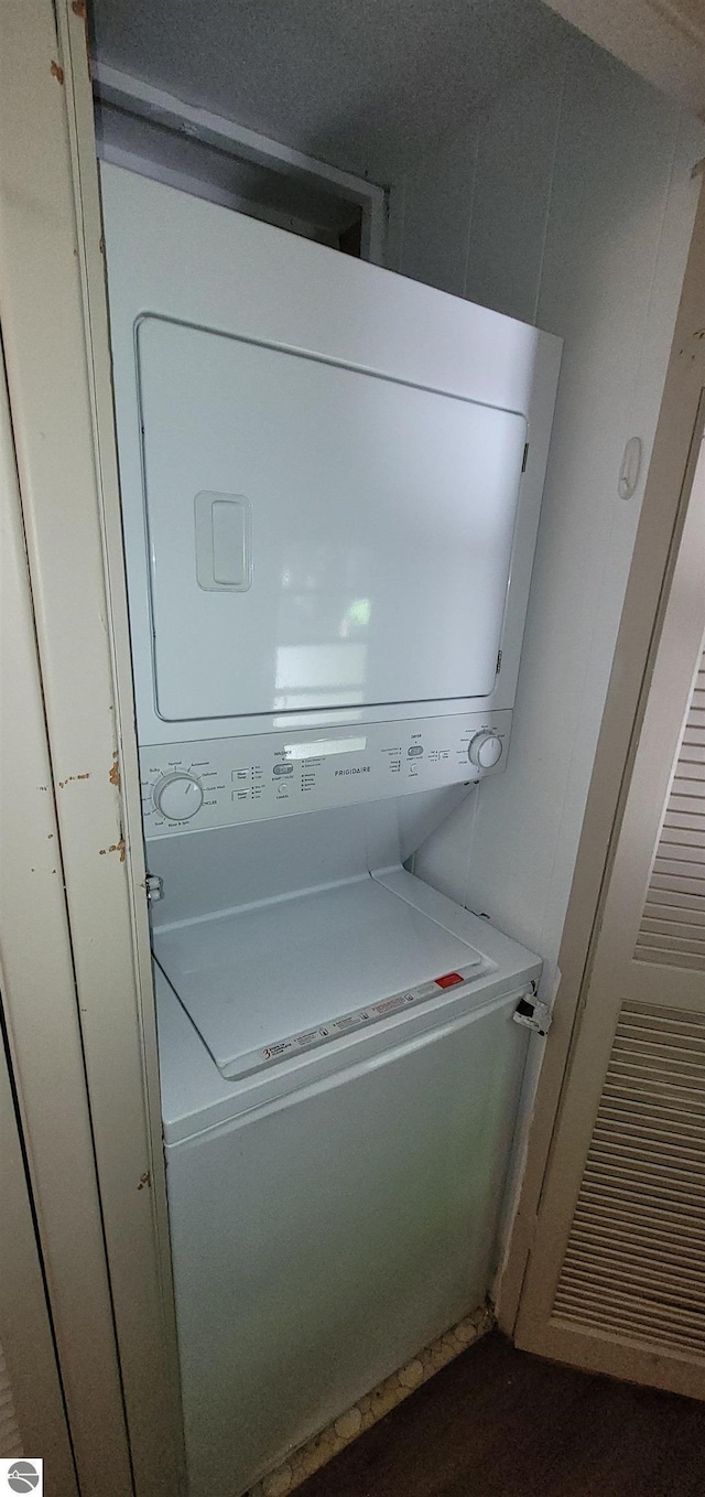 washroom featuring stacked washing maching and dryer and laundry area