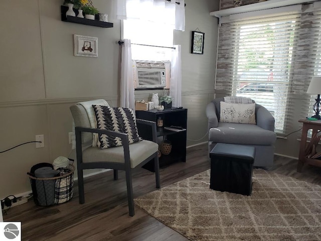 living area featuring cooling unit and dark wood-type flooring