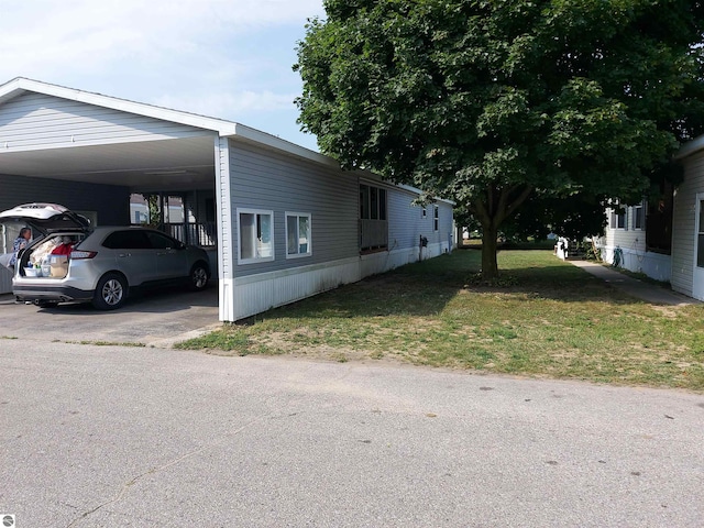 view of side of property featuring a yard and a carport