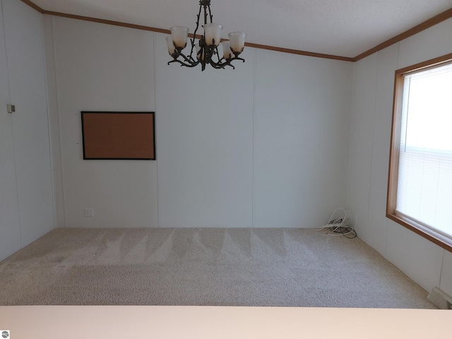 spare room featuring carpet floors, a chandelier, and crown molding