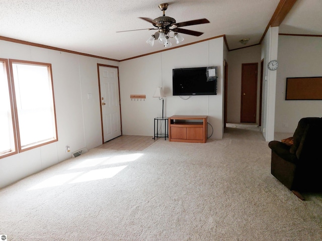 unfurnished living room featuring ceiling fan, crown molding, a textured ceiling, and light carpet