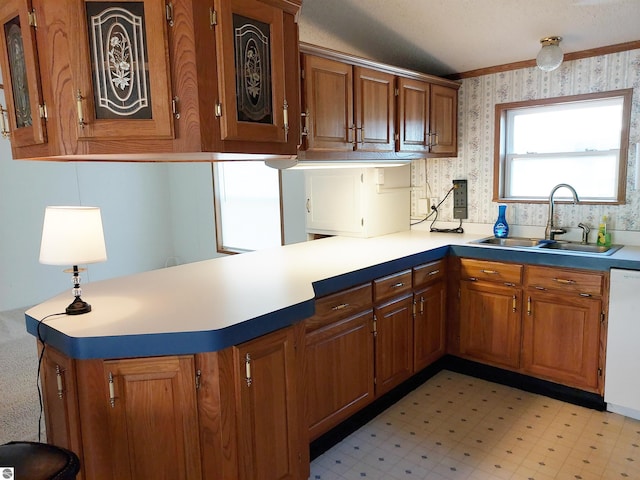 kitchen with sink, kitchen peninsula, light tile patterned flooring, and white dishwasher