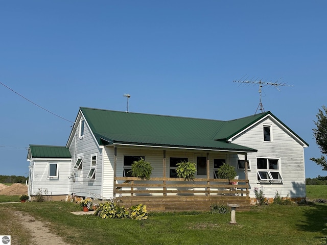 view of front of property with metal roof, a porch, and a front yard