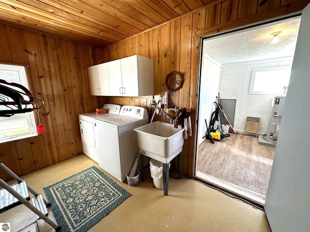 laundry room featuring wooden ceiling, independent washer and dryer, cabinet space, and wooden walls