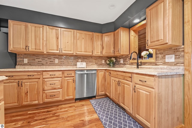 kitchen featuring dishwasher, sink, light hardwood / wood-style floors, and tasteful backsplash